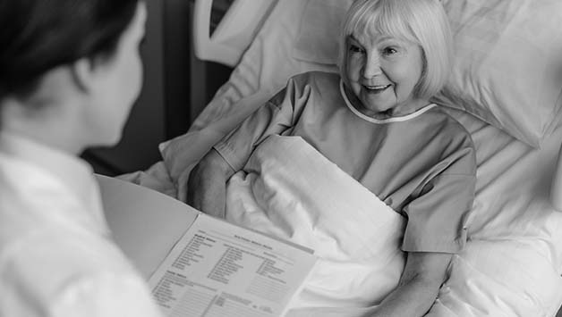 senior woman in hospital bed talking to doctor